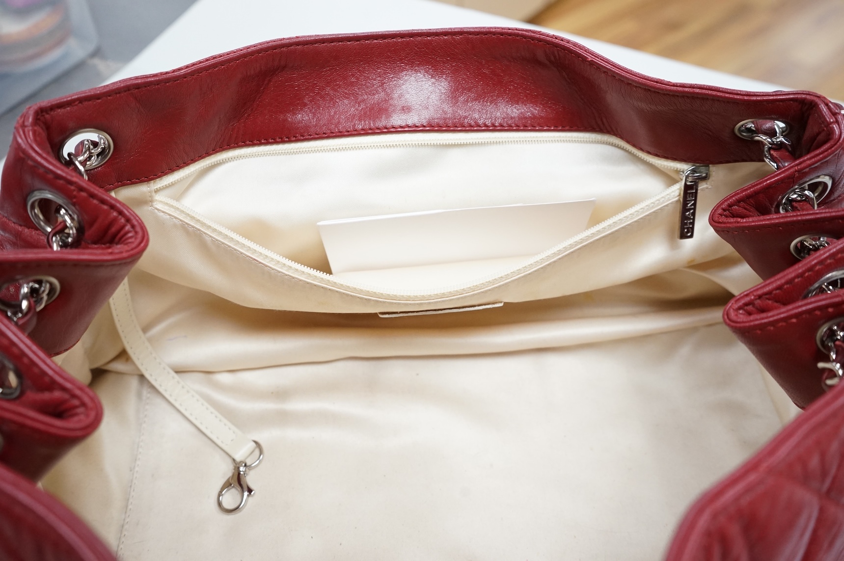 A Chanel East West dark red quilted leather flap shoulder bag with silver hardware, date code 12115484, with original receipt, dust cover and box, 35cm wide, Provenance: purchased by the vendor in Selfridges